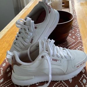 White puma sneakers with pink gold accents